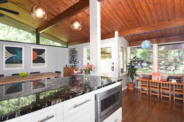 kitchen with stainless steel microwave, wood ceiling, lofted ceiling with beams, and dark wood-type flooring