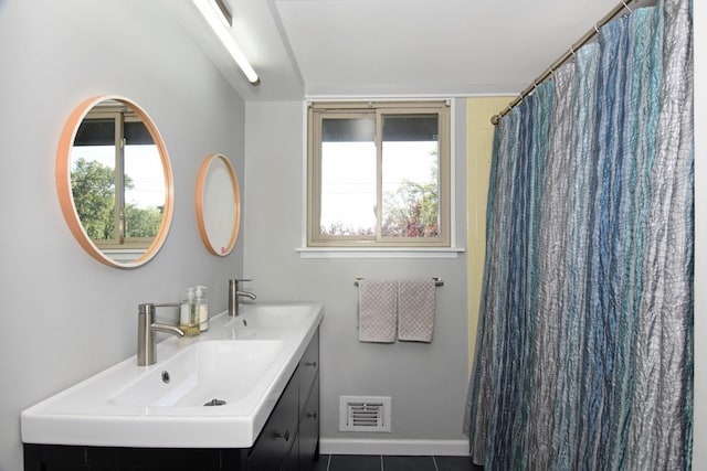 full bath featuring double vanity, visible vents, tile patterned flooring, and a sink