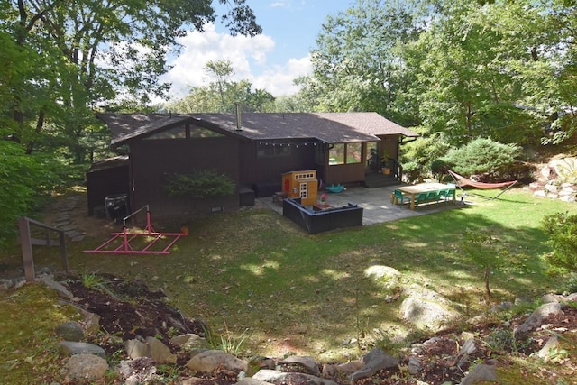 back of property with a yard, a patio area, roof with shingles, and crawl space