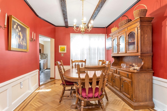 dining area with beamed ceiling, a decorative wall, a notable chandelier, and wainscoting