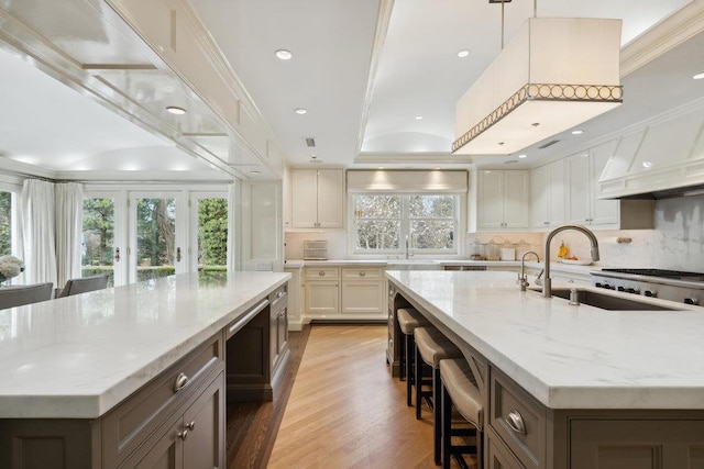 99 Wheatley Rd, Old Westbury, NY 11568 - kitchen featuring a kitchen breakfast bar, a spacious island, light wood-type flooring, backsplash, and light stone counters