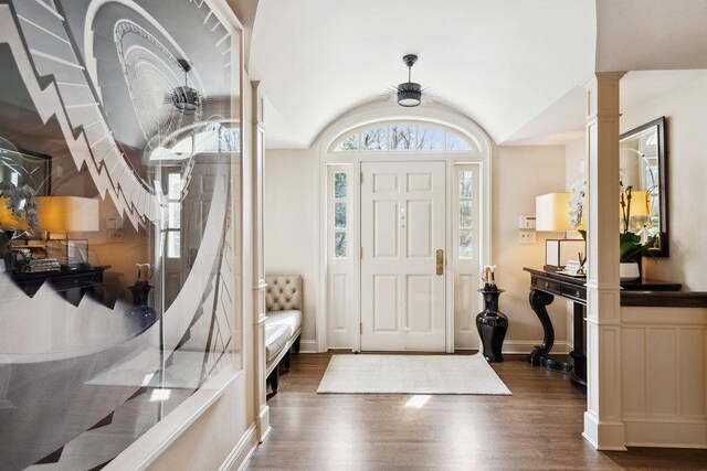 99 Wheatley Rd, Old Westbury, NY 11568 - entryway with baseboards, vaulted ceiling, ornate columns, and dark wood-style floors