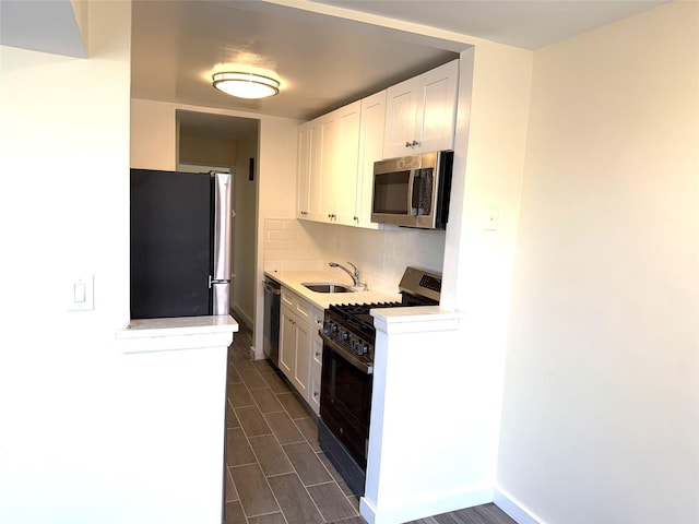 kitchen featuring light countertops, white cabinetry, appliances with stainless steel finishes, and tasteful backsplash