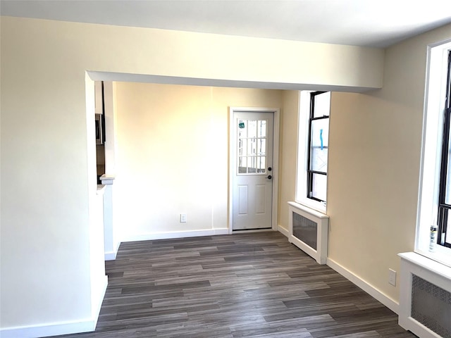 empty room featuring dark wood-style flooring and baseboards