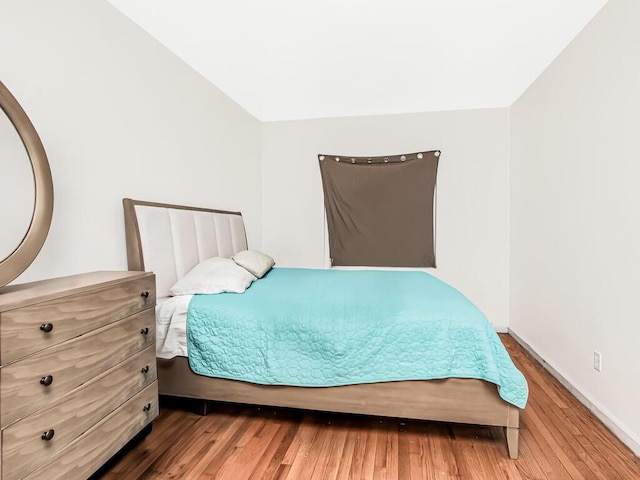 bedroom featuring baseboards and wood finished floors