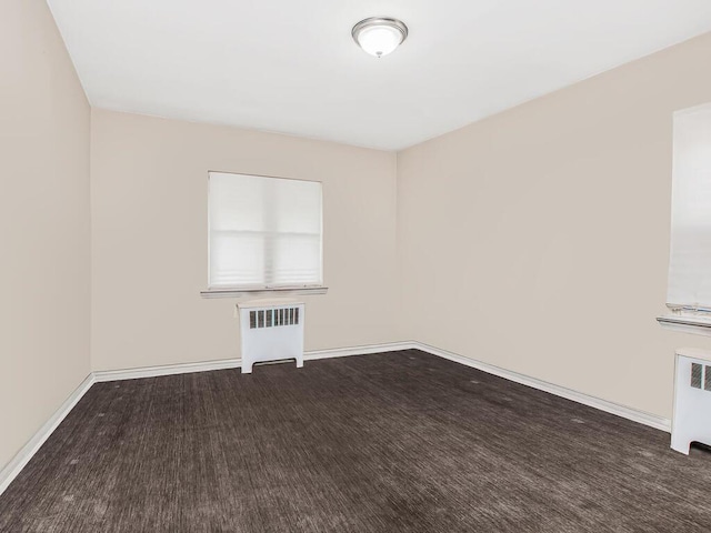 carpeted spare room with radiator heating unit and baseboards