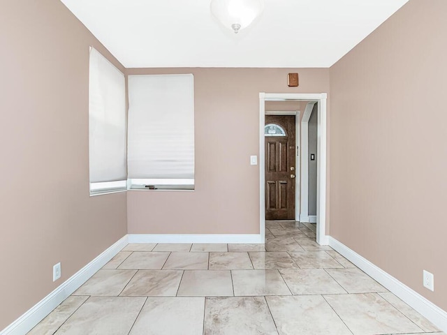 unfurnished room with baseboards and marble finish floor