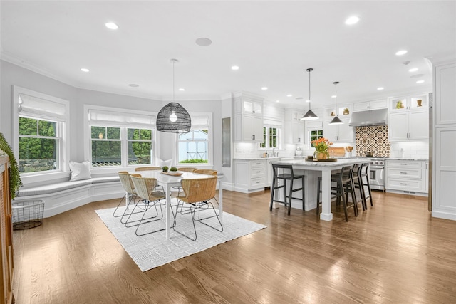 dining space featuring crown molding, recessed lighting, and wood finished floors