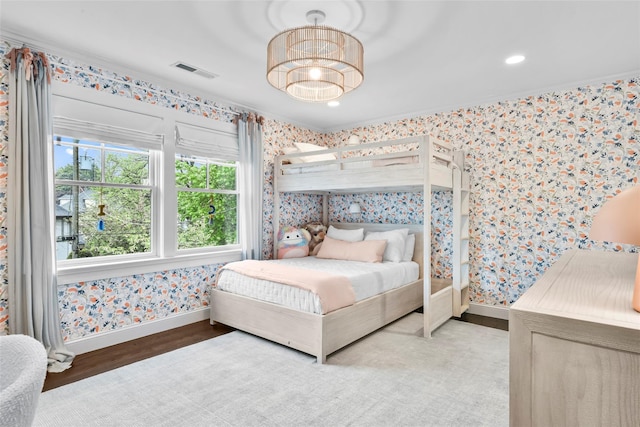 bedroom with wood finished floors, baseboards, wallpapered walls, and visible vents