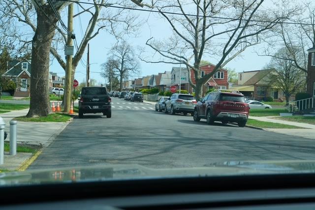 view of street with curbs, traffic signs, sidewalks, and a residential view