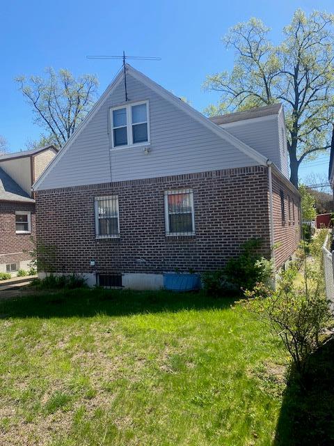 view of home's exterior with a lawn and brick siding