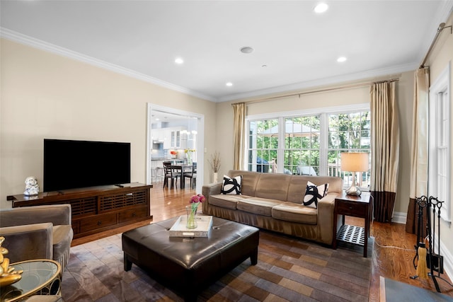 living room with baseboards, ornamental molding, recessed lighting, and wood finished floors
