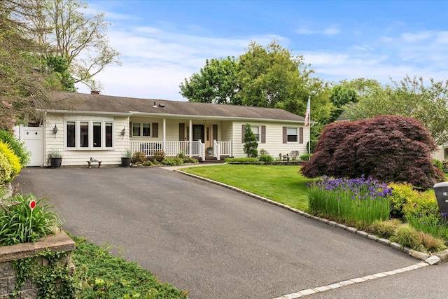 24 Akron Pl, Shoreham, NY 11786 - single story home featuring a porch, asphalt driveway, a front yard, and a chimney