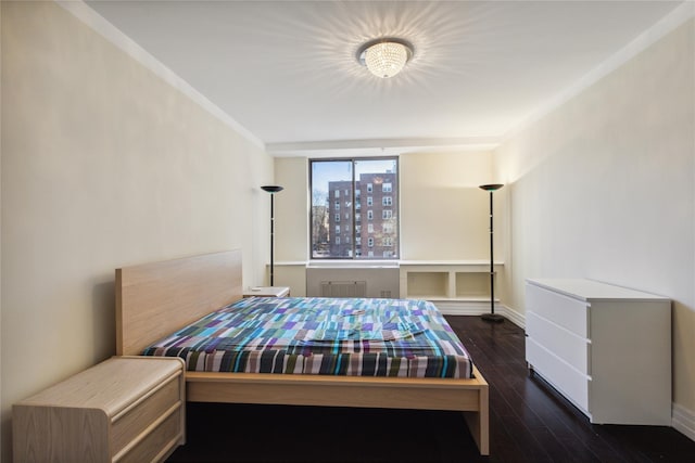 bedroom with baseboards and wood finished floors