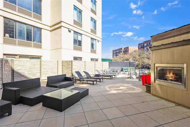 view of patio featuring fence and an outdoor living space with a fireplace