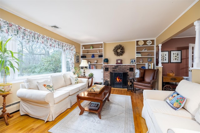 living room with baseboard heating, a brick fireplace, wood finished floors, visible vents, and ornamental molding