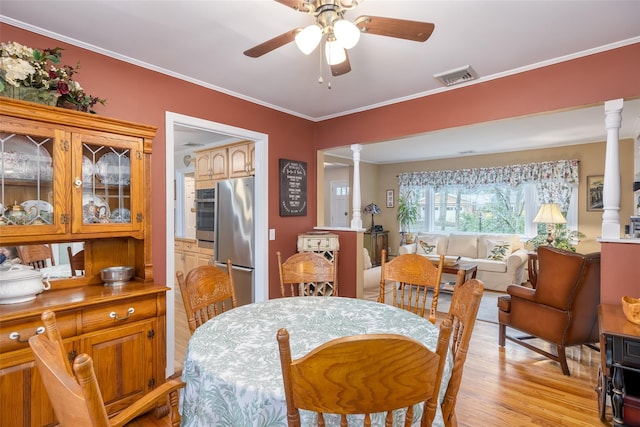 dining area with ornate columns, ceiling fan, visible vents, and light wood-type flooring