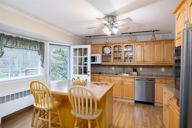 kitchen featuring a breakfast bar area, white microwave, ornamental molding, and dishwasher