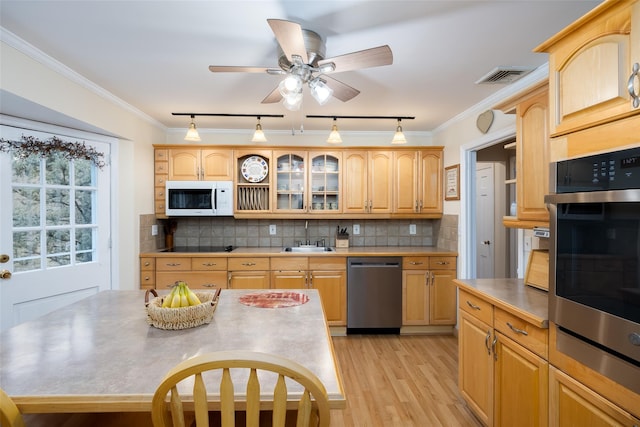 kitchen featuring a sink, dishwasher, rail lighting, light wood-style flooring, and white microwave