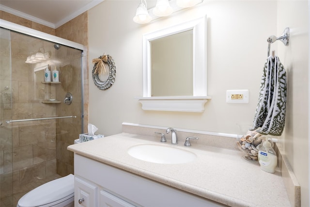 bathroom with crown molding, toilet, a shower stall, and vanity