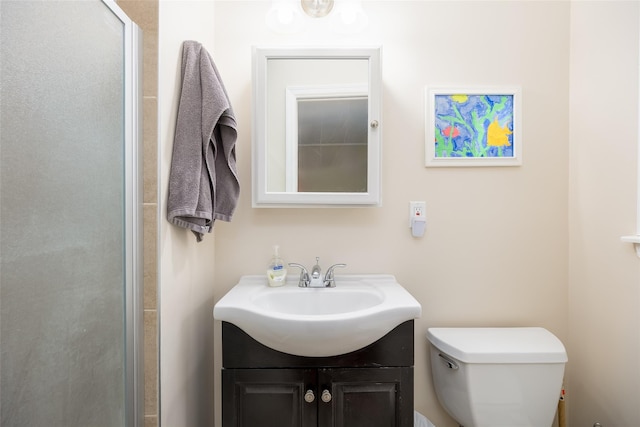 full bathroom featuring toilet, a shower with door, and vanity