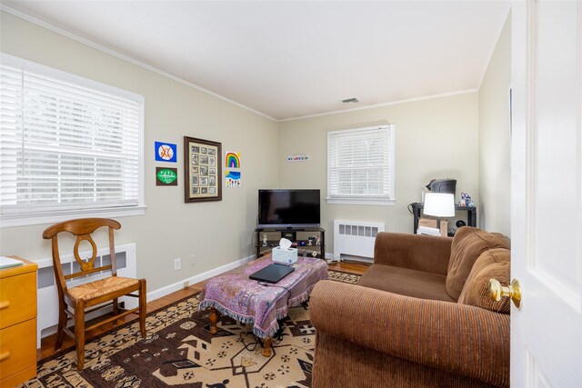 living area featuring crown molding, wood finished floors, and radiator