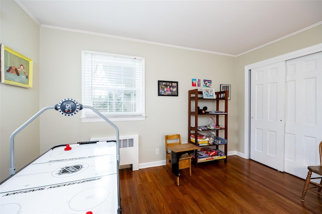 recreation room with baseboards, ornamental molding, and wood finished floors