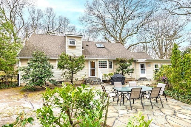 back of house with fence, outdoor dining area, a shingled roof, a patio area, and entry steps
