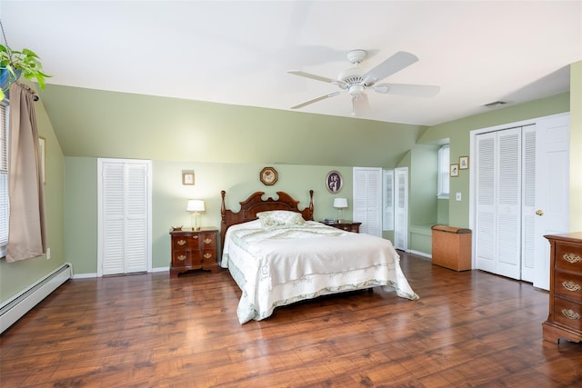 bedroom featuring multiple closets, wood finished floors, lofted ceiling, a baseboard heating unit, and visible vents