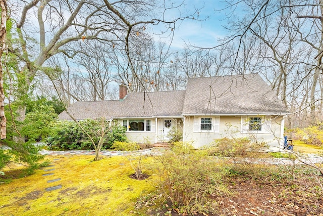 view of front of house with roof with shingles and a chimney