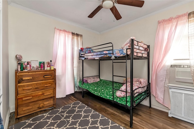 bedroom with ornamental molding, wood finished floors, and radiator heating unit