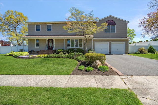 view of front of house with fence, covered porch, an attached garage, and aphalt driveway