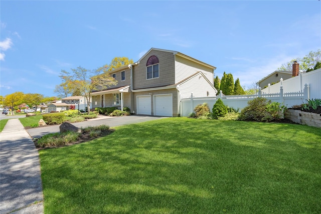 view of front of home with concrete driveway, fence, a front yard, and a garage