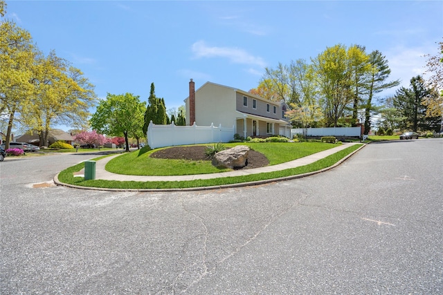 view of side of home with fence and a chimney