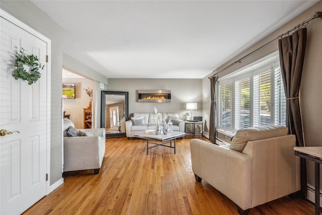 living room with baseboards and light wood-style flooring