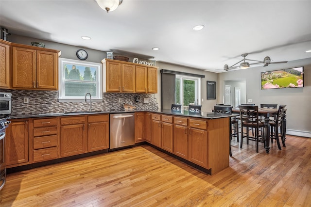 kitchen featuring brown cabinetry, light wood-style flooring, and dishwasher