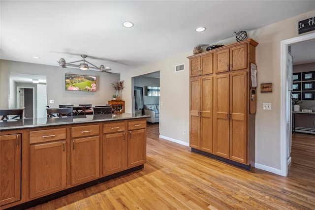 kitchen with ceiling fan, light wood-style floors, brown cabinetry, recessed lighting, and visible vents