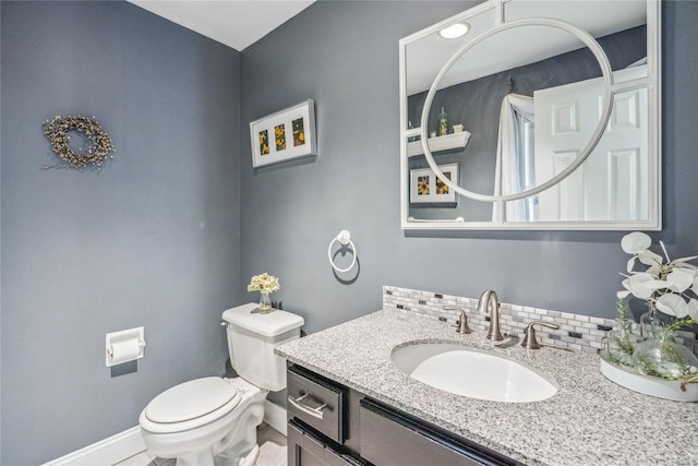 bathroom with vanity, baseboards, and toilet