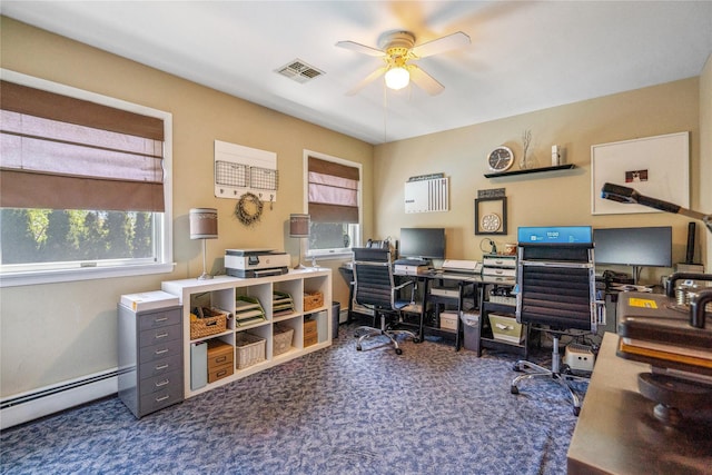 office area with visible vents, baseboard heating, a ceiling fan, and a wealth of natural light