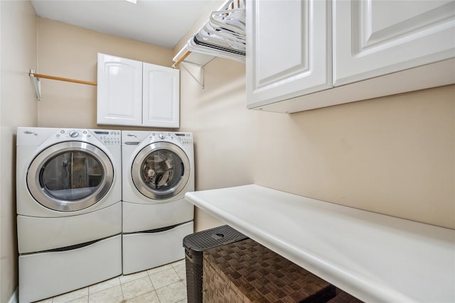 washroom featuring cabinet space, light tile patterned floors, and washing machine and dryer
