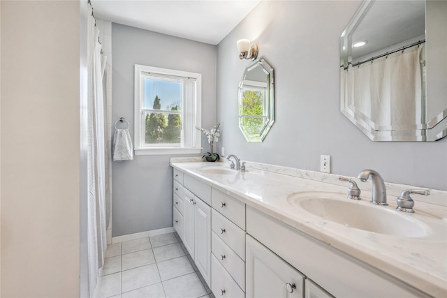 full bathroom with a sink, baseboards, tile patterned flooring, and double vanity