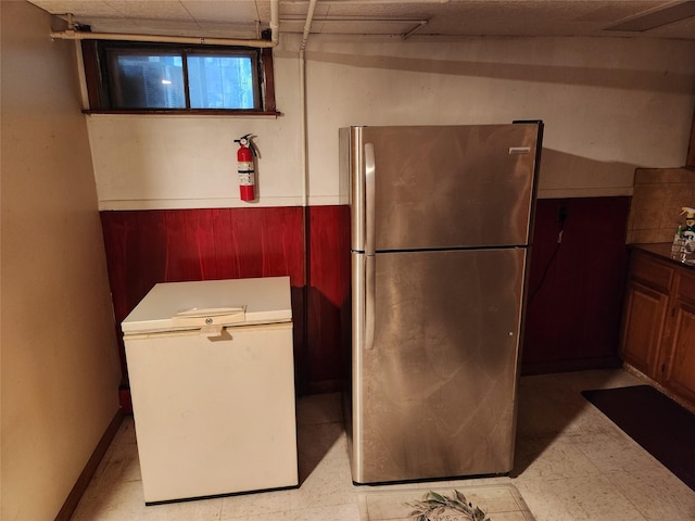 112 Rutland Rd, Hempstead, NY 11550 - kitchen with freestanding refrigerator, wood walls, light floors, and a wainscoted wall