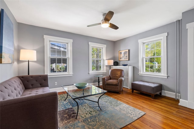 living room featuring a ceiling fan, a wealth of natural light, wood finished floors, and baseboards