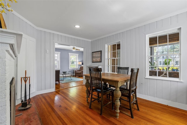 dining room with crown molding, baseboards, recessed lighting, and wood-type flooring