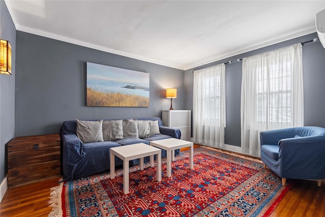 living area with wood finished floors, ornamental molding, and baseboards