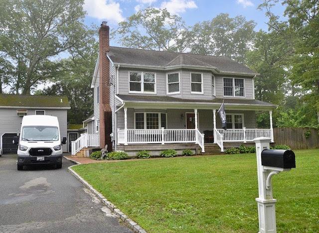 20 Richmond Blvd, Lake Grove, NY 11755 - view of front facade featuring a chimney, covered porch, and driveway