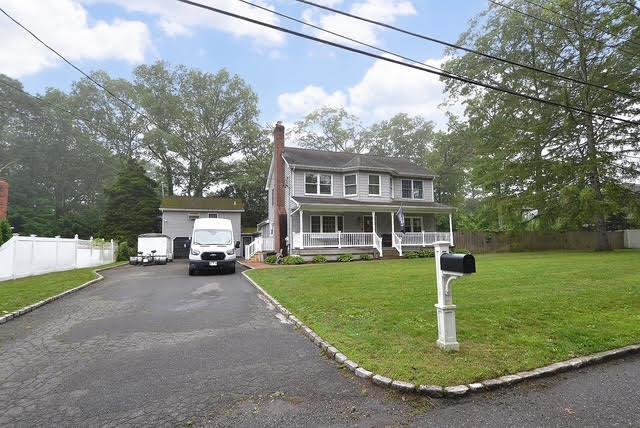 20 Richmond Blvd, Lake Grove, NY 11755 - colonial house featuring a porch, a chimney, and asphalt driveway