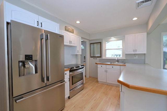 20 Richmond Blvd, Lake Grove, NY 11755 - kitchen with appliances with stainless steel finishes, light wood-type flooring, white cabinets, light countertops, and a peninsula