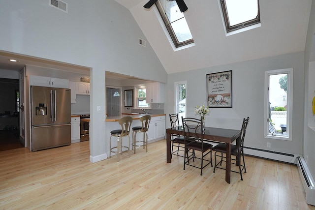20 Richmond Blvd, Lake Grove, NY 11755 - dining room featuring high vaulted ceiling, light wood-style floors, a baseboard heating unit, and a skylight