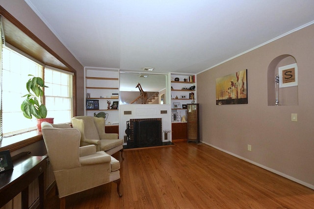 20 Richmond Blvd, Lake Grove, NY 11755 - living area featuring wood finished floors, crown molding, built in features, and a brick fireplace